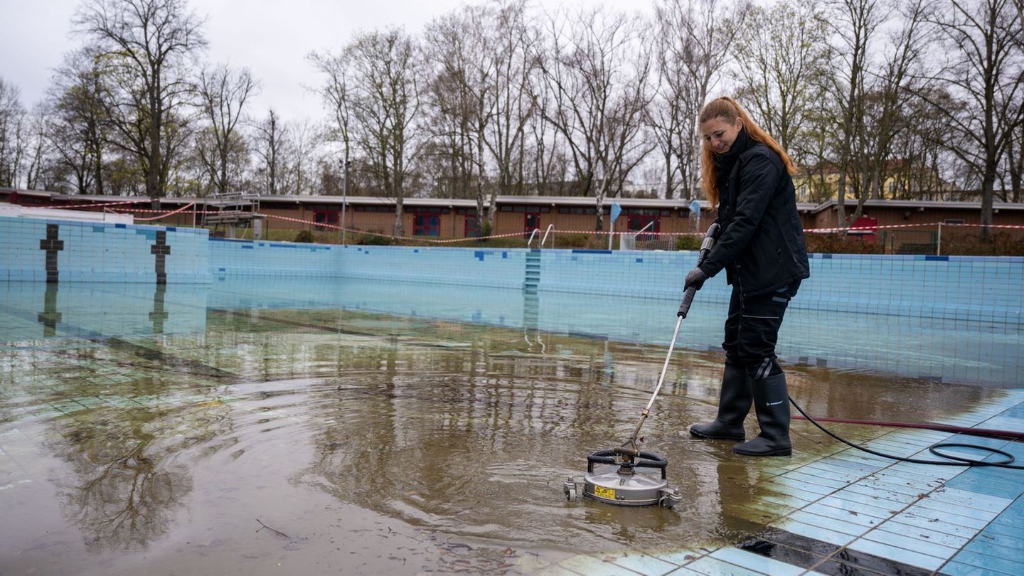 Diana Reimann, Badleiterin vom Sommerbad Humboldthain der Berliner Bäder-Betriebe, reinigt die Fliesen im Schwimmbecken. Foto: C