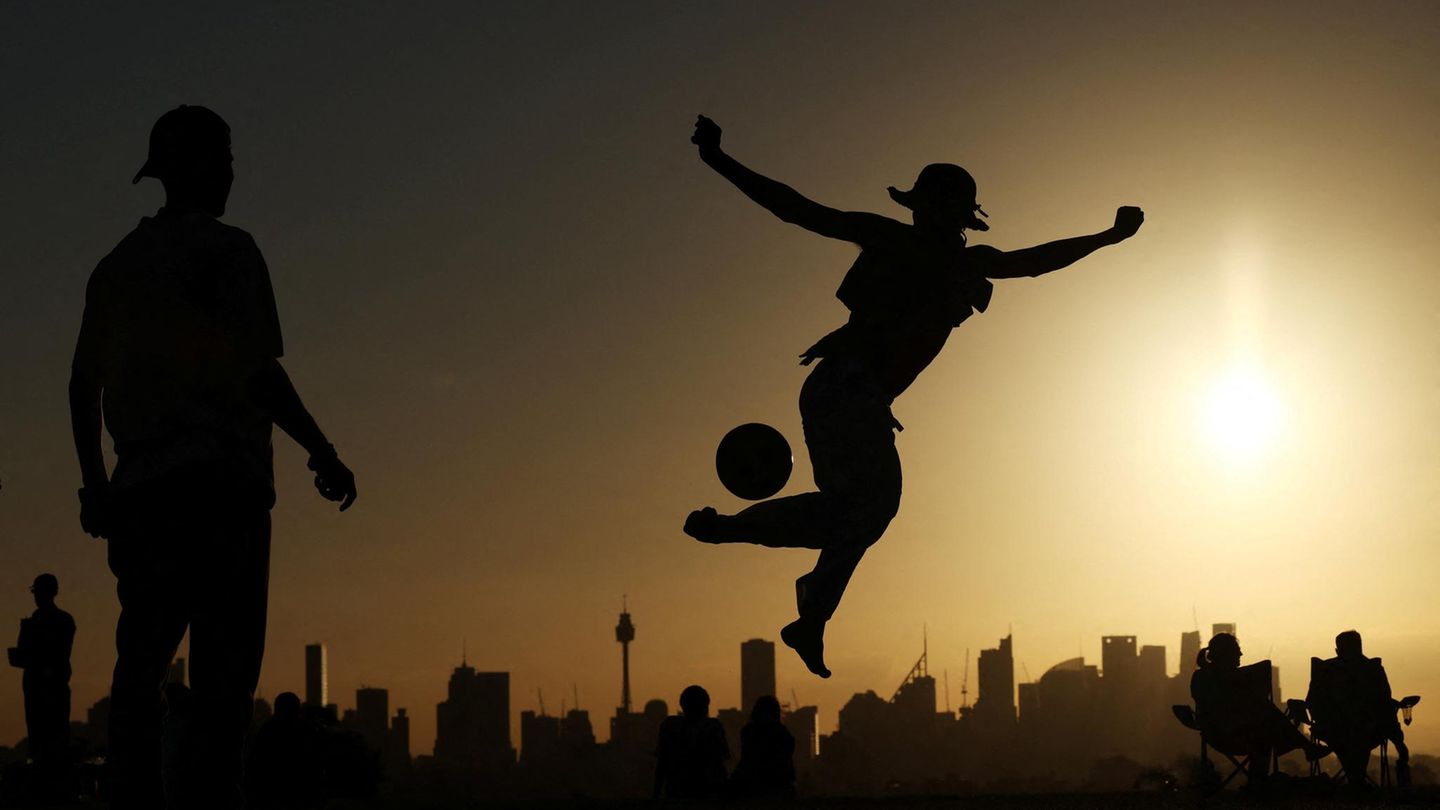 Sydney, Australien. Die Vorfreude auf die Weltmeisterschaft in diesem Sommer scheint auch in Australien zu steigen: Im Sonnenuntergang wird vor der Skyline der Stadt gekickt.