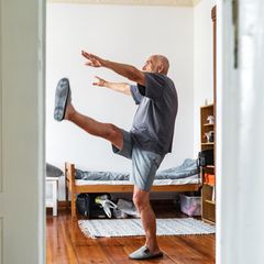 Bewegung: Ein älterer Herr macht zuhause seine Fitnessübungen