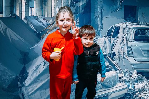 Montage: Zwei Kinder vor einem geteilten Hintergrund: Links Zelte als Notunterkunft, rechts zerstörte Autos im Libanon