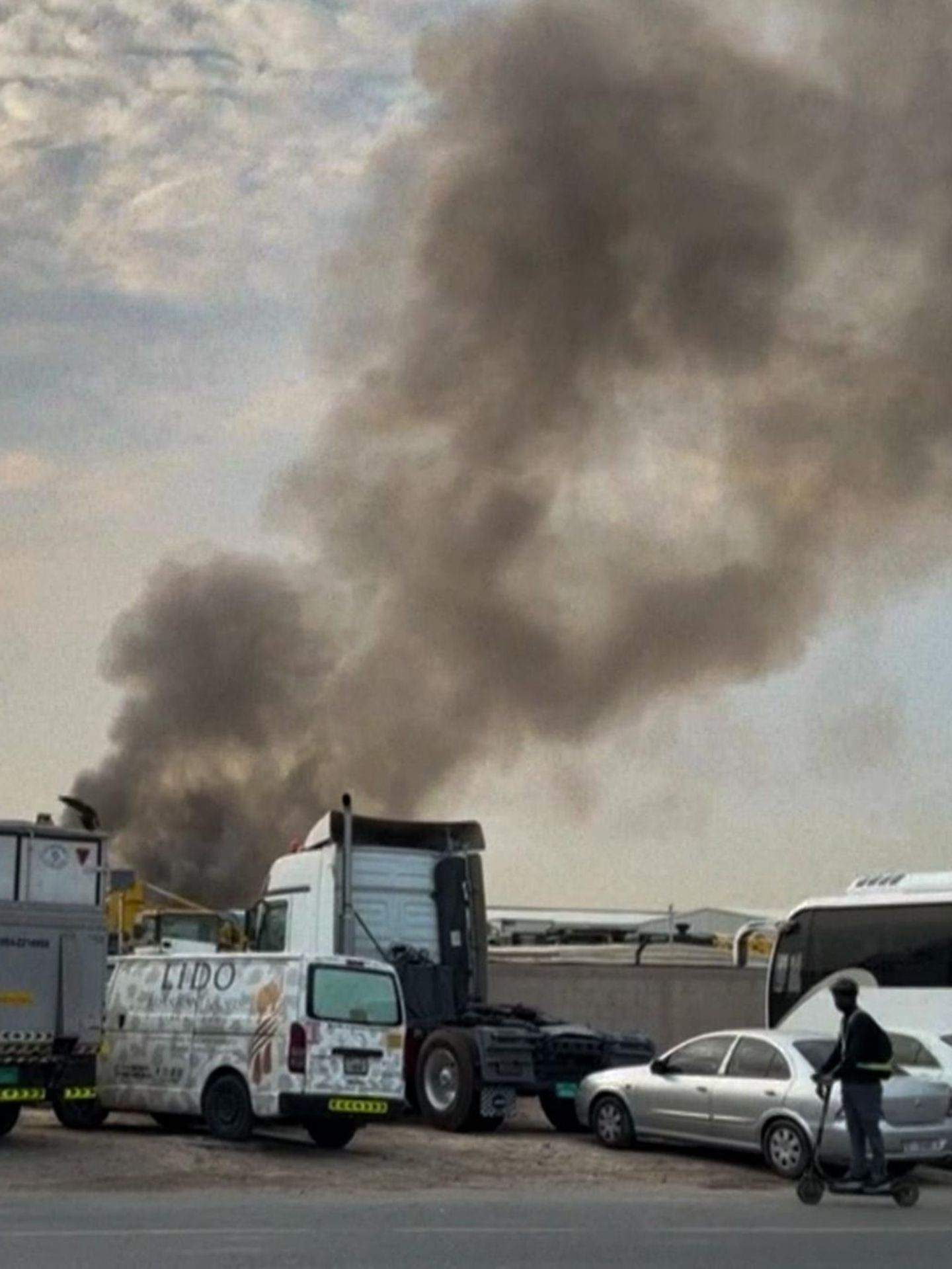 Rauchwolke am Himmel über abgestellten LKW