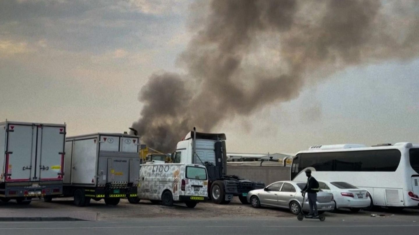 Rauchwolke am Himmel über abgestellten LKW