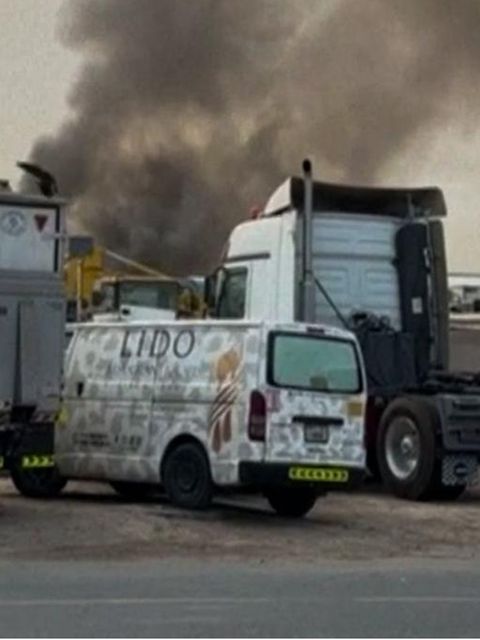 Rauchwolke am Himmel über abgestellten LKW