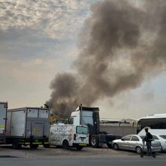 Rauchwolke am Himmel über abgestellten LKW