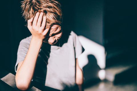 Migräne bei Kindern: Ein Schulkind greift sich an den Kopf