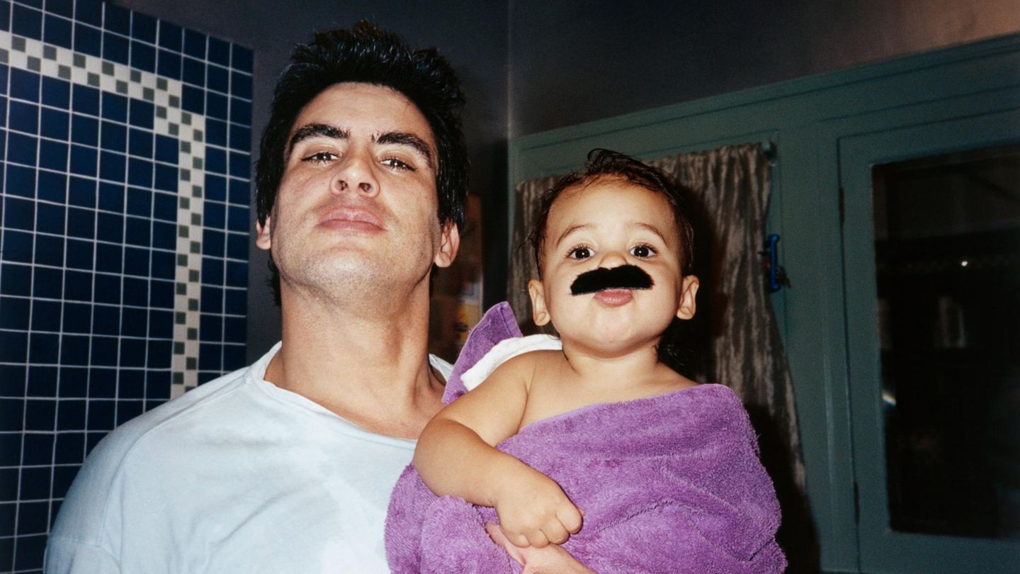 Ein Vater steht mit seinem Kind vor dem Spiegel