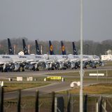 Lufthansa Flugzeuge stehen in Reihe geparkt und eingemottet auf dem Vorfeld eines Flughafens