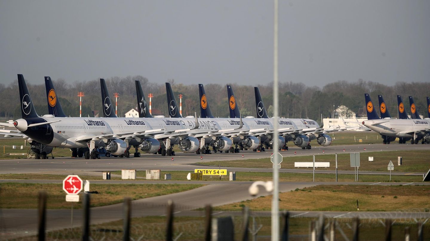 Lufthansa Flugzeuge stehen in Reihe geparkt und eingemottet auf dem Vorfeld eines Flughafens