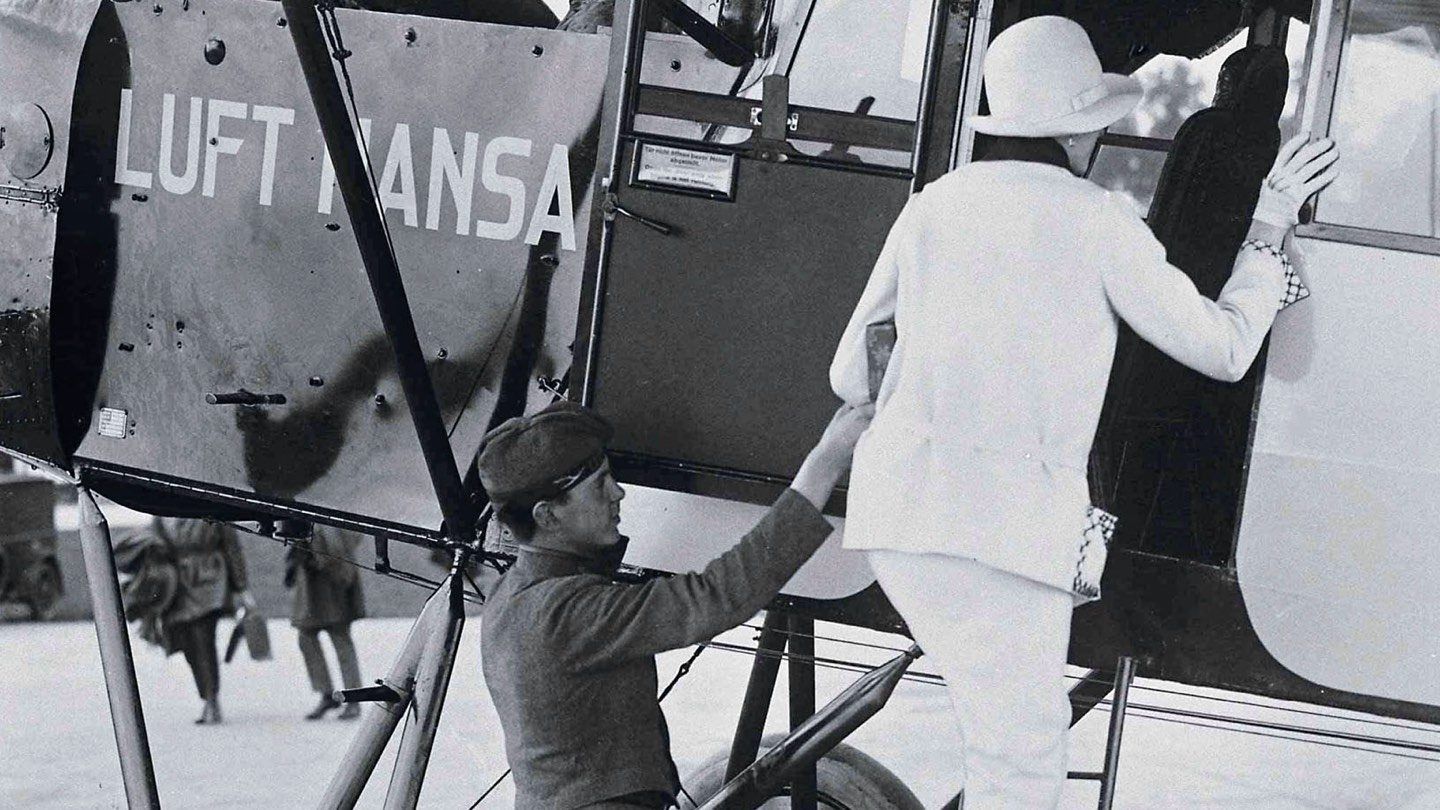 Eine Frau steigt in eine Fokker F 2 ein