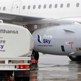 Ein Tanklaster betankt ein Lufthansa Flugzeug mit Bio-Kraftstoff