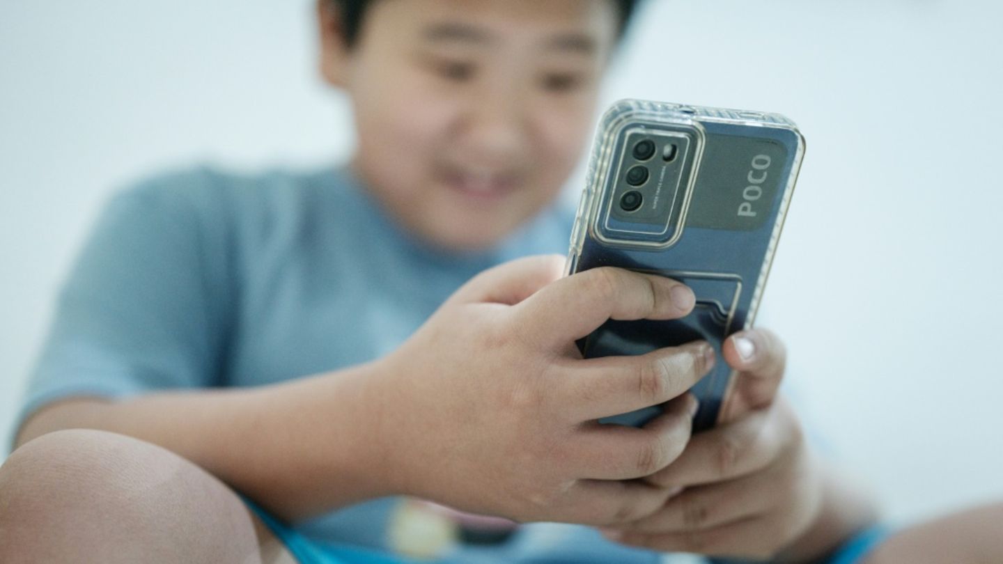 Kind mit Handy in Indonesien