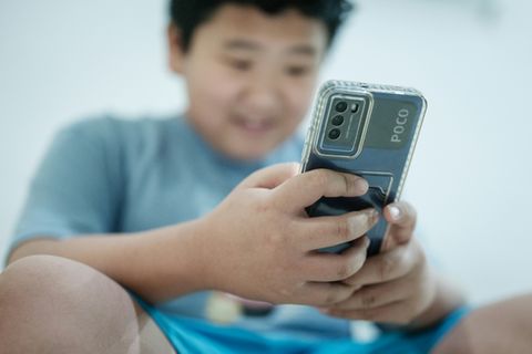 Kind mit Handy in Indonesien