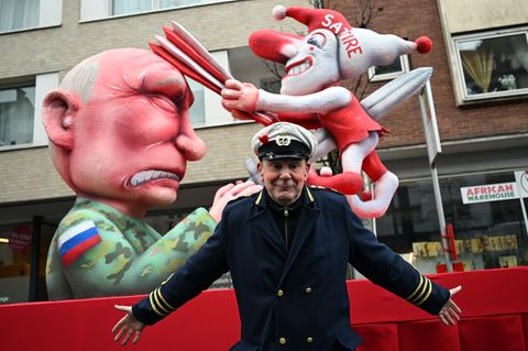 Jacques Tilly breitet vor einem seiner Karnevalswagen gegen Kremlchef Wladimir Putin die Arme aus