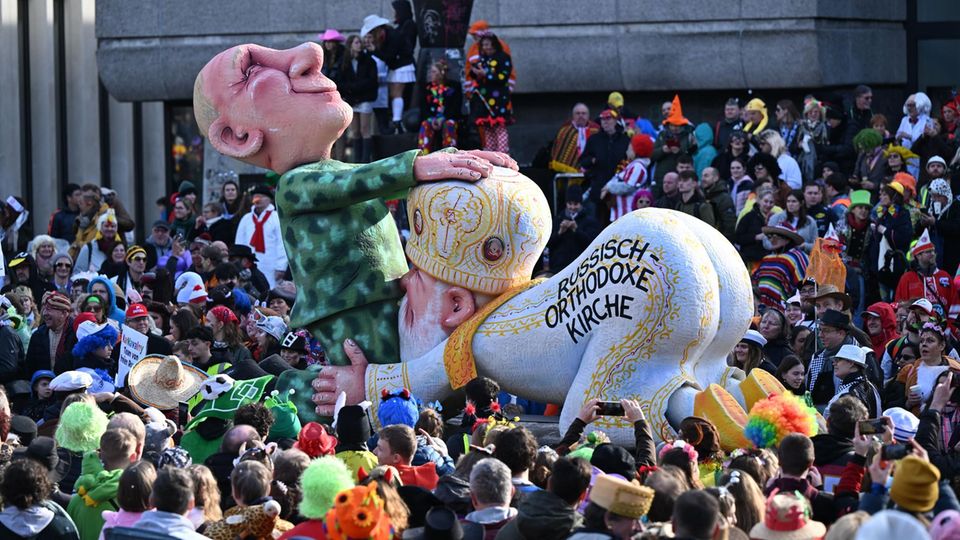 Ein Karnevalswagen von Jacques Tilly zeigt, wie der russische Patriarch Präsident Putin oral befriedigt