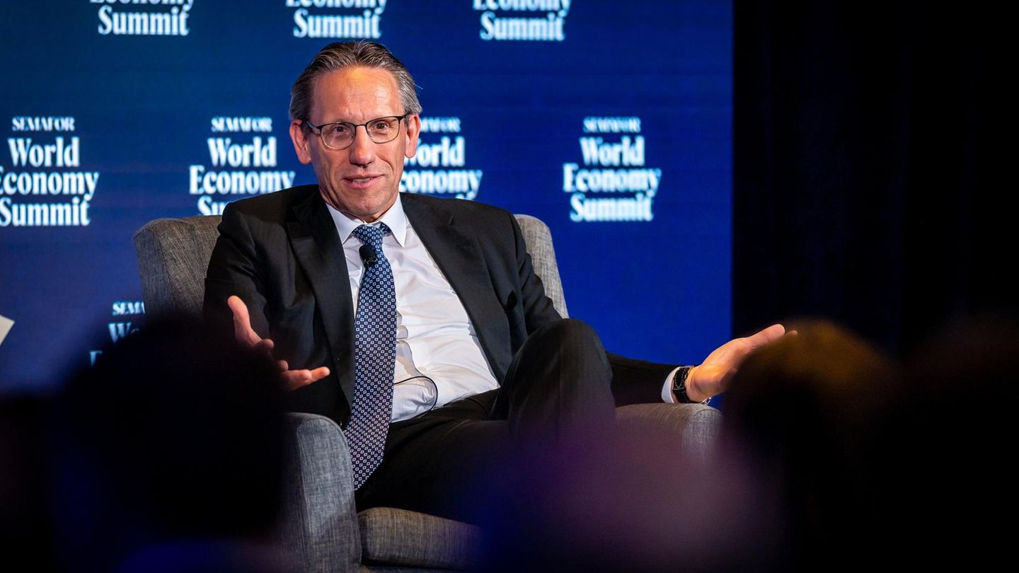 Jörg Kukies sitzt auf einem Panel