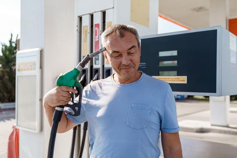 Steigender Diesel-Preis: Ein Mann hält sich eine Zapfpistole an den Kopf