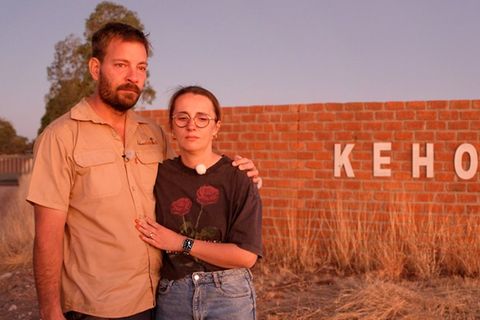 Gerald und Anna stehen ein letztes Mal vor dem Gelände ihrer Farm in Namibia.
