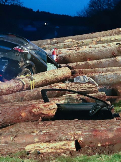 Der Pkw fuhr am Freitagabend in einen Holzstapel. Foto: Sabine Süß/Vifogra GmbH/dpa