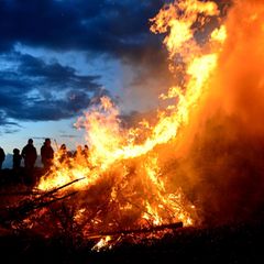 Ein Osterfeuer lodert in der Dämmerung: Der traditionelle Brauch steht zwischen geselligem Frühlingsevent und der Kritik von Nat