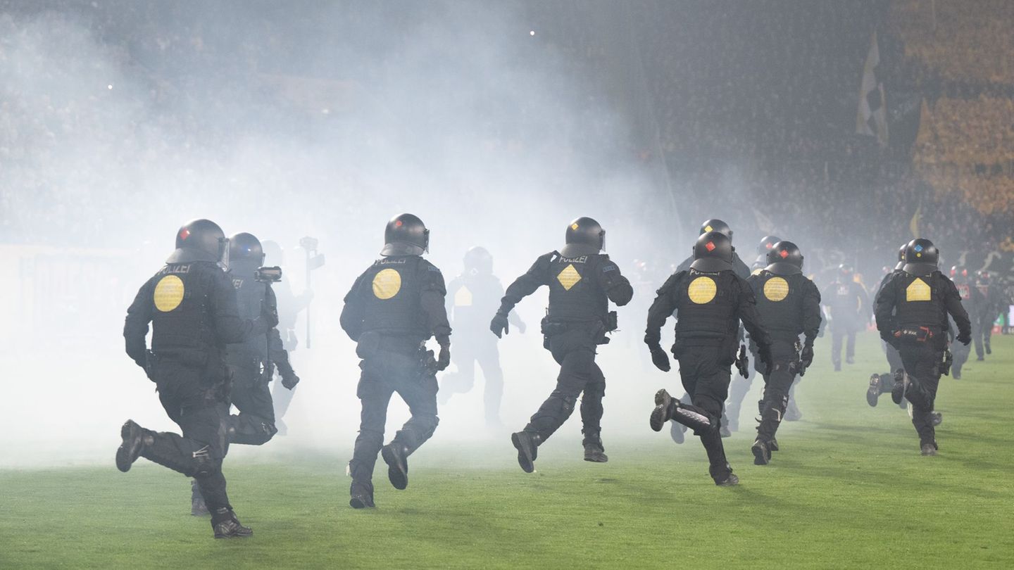 Die Polizei versuchte, Dynamo-Fans wieder in ihren Block zurückzudrängen. Foto: Sebastian Kahnert/dpa