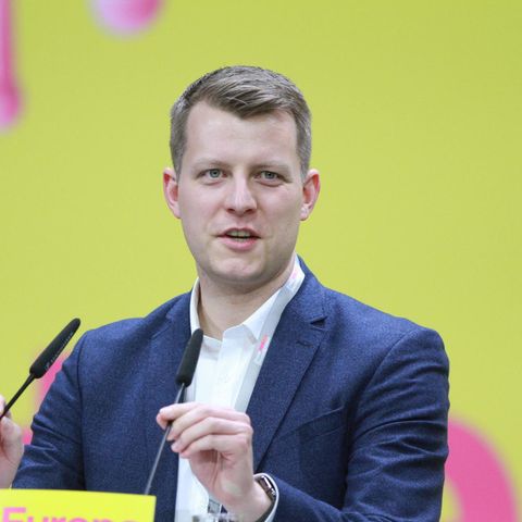 FDP-Politiker Henning Höne an einem Rednerpult vor gelbem Hintergrund