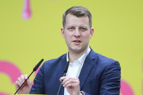 FDP-Politiker Henning Höne an einem Rednerpult vor gelbem Hintergrund