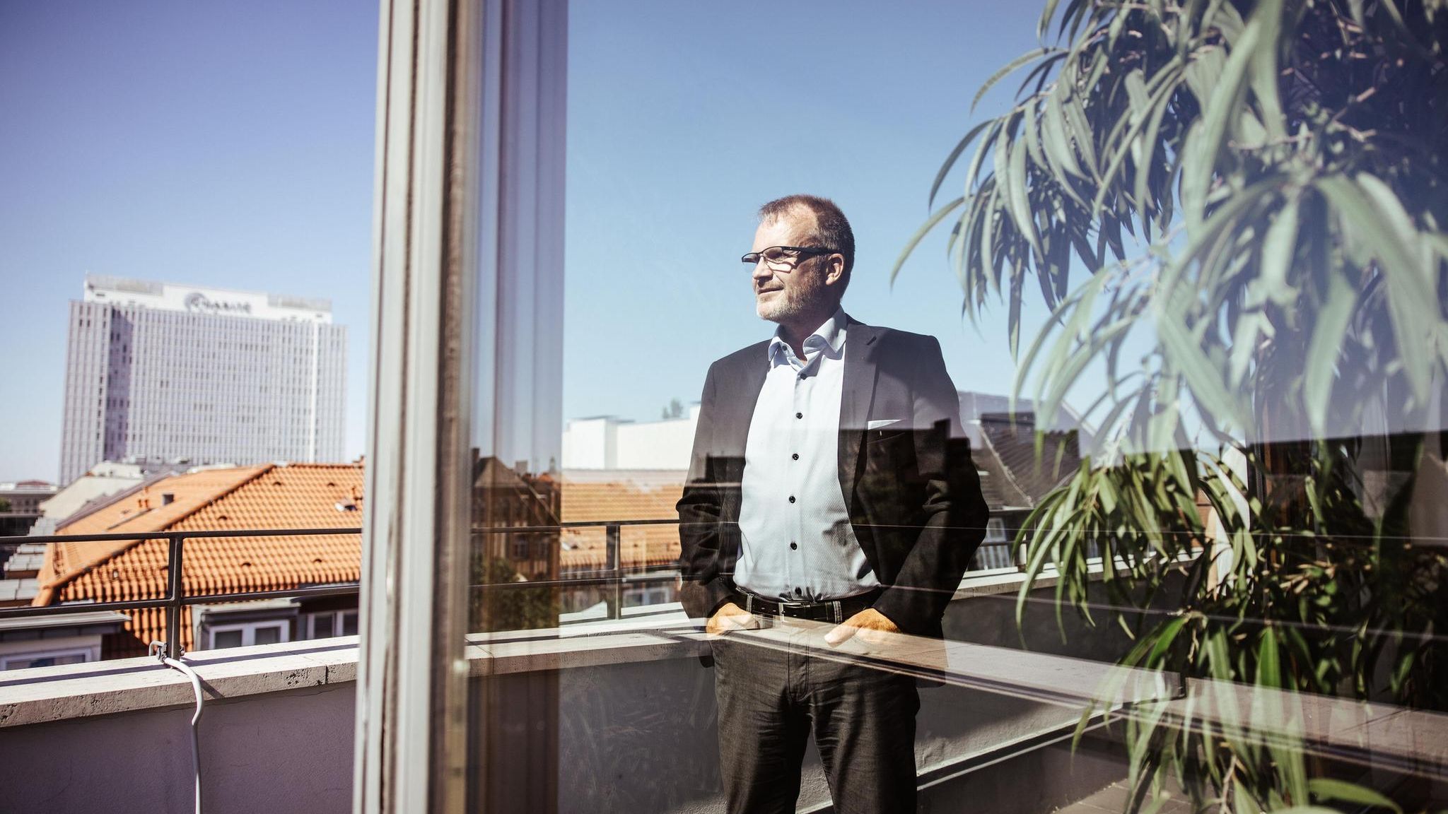 Krankenkassen-Chef Jens Baas steht auf einem Balkon