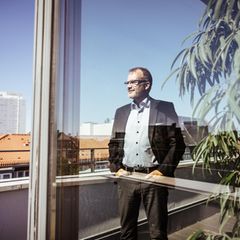 Krankenkassen-Chef Jens Baas steht auf einem Balkon