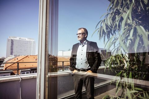 Krankenkassen-Chef Jens Baas steht auf einem Balkon