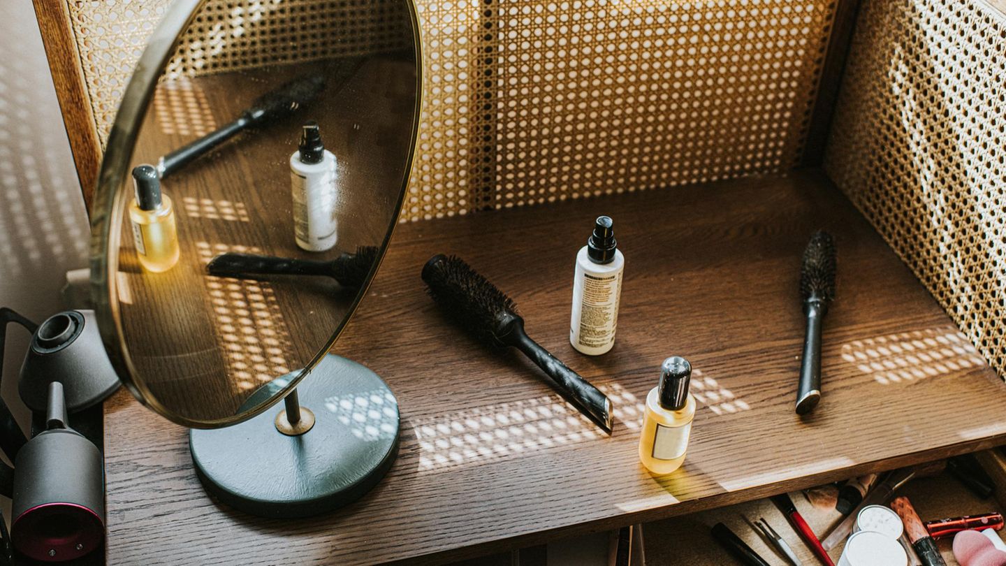 ein Make-Up Tisch mit Spiegel und verschiedenen Produkten