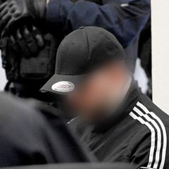 Der Hauptangeklagte (r.) wartet im Landgericht auf den Beginn des Prozesses um Autorennen