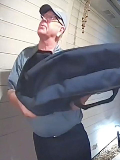 Ein Pizzalieferant steht vor einem Haus.