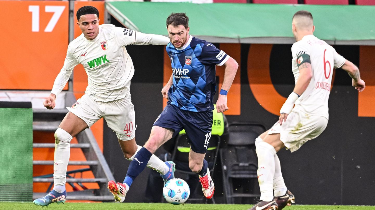 Wer wird's? Noahkai Banks (l) oder Jeffrey Gouweleeuw (r) beginnen am Freitag für Augsburg. (Archivbild) Foto: Harry Langer/dpa