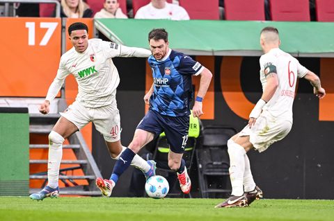 Wer wird's? Noahkai Banks (l) oder Jeffrey Gouweleeuw (r) beginnen am Freitag für Augsburg. (Archivbild) Foto: Harry Langer/dpa