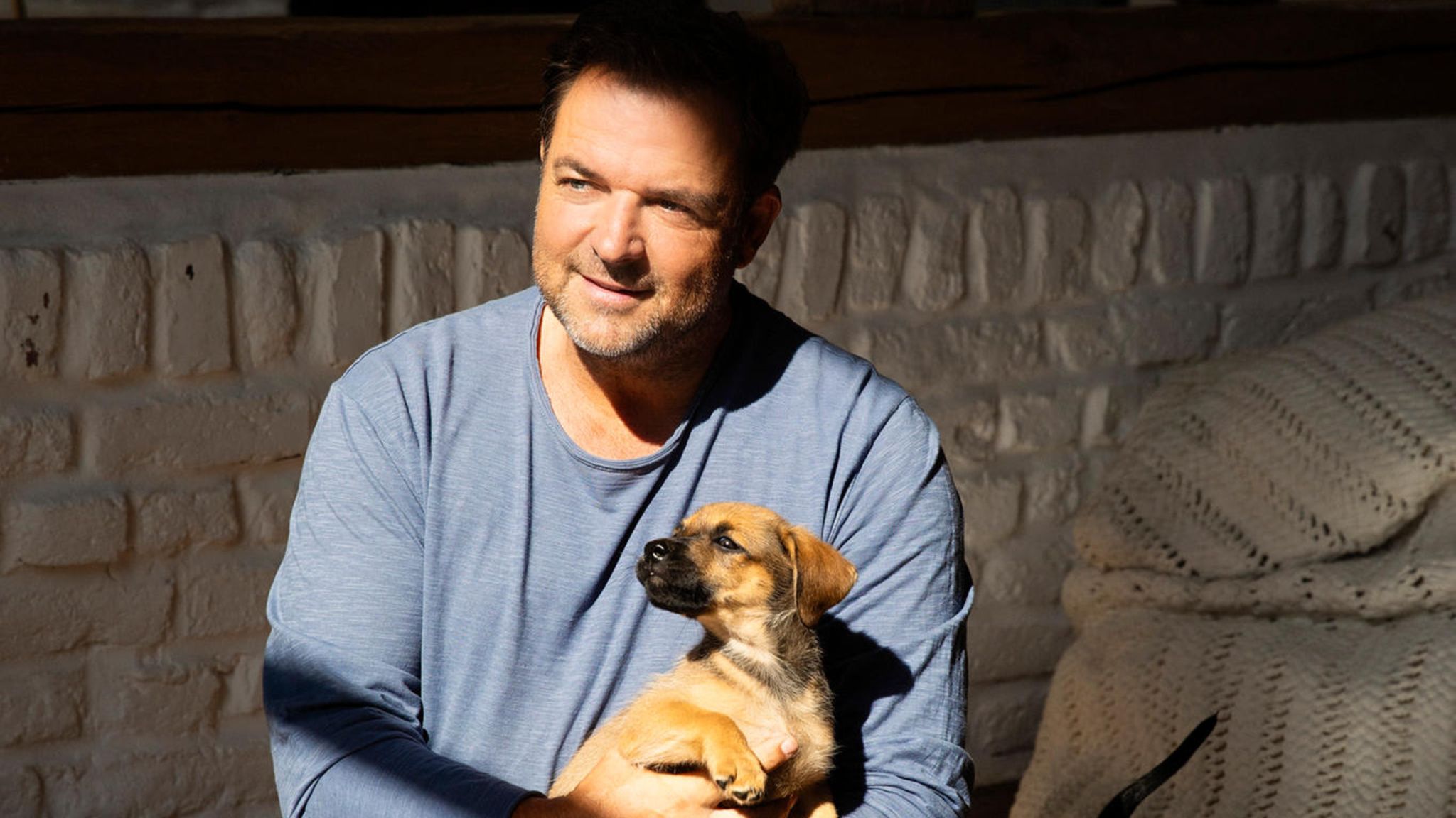 Martin Rütter umgeben von Welpen