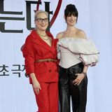 Meryl Streep im roten Anzug neben Hathaway, die eine schwarze Lederhose trägt