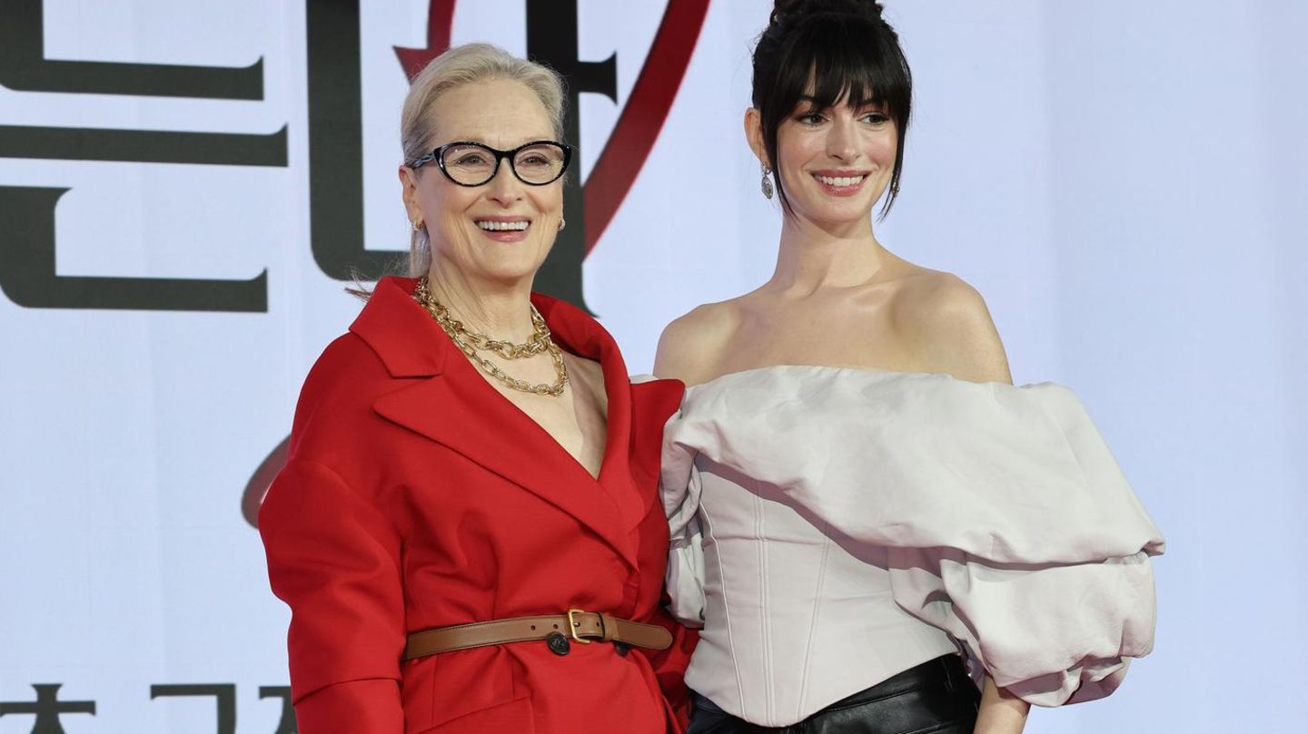 Meryl Streep im roten Anzug neben Hathaway, die eine schwarze Lederhose trägt