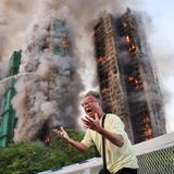 Mann schreit vor brennendem Wohnkomplex