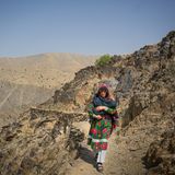 Frau trägt Kind in Arm