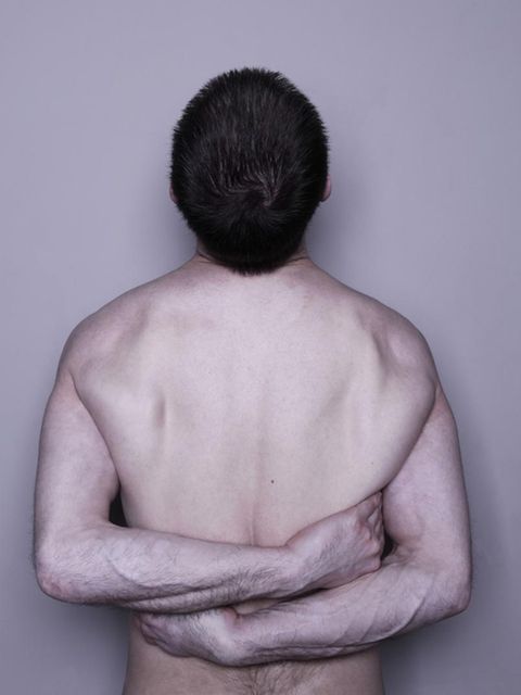 Ein nackter, männlicher Oberkörper eines Narzissten umarmt sich selbst