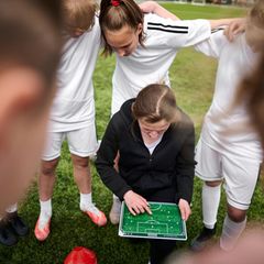 Fußballtrainerin inmitten der Spieler