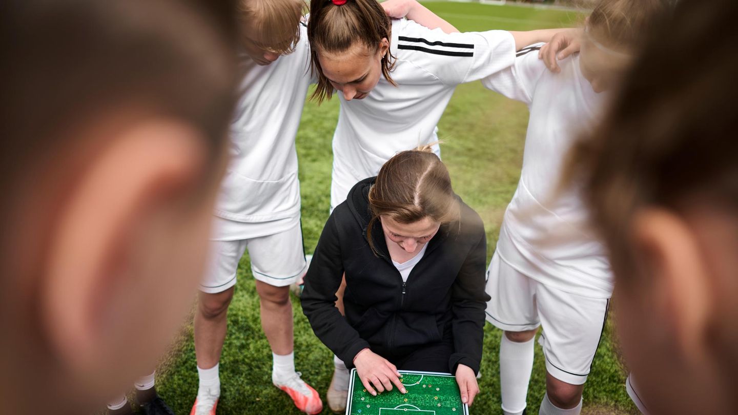 Fußballtrainerin inmitten der Spieler