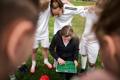Fußballtrainerin inmitten der Spieler