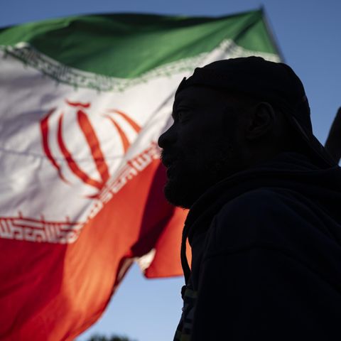 Der Schatten eines Mannes vor der iranischen Flagge