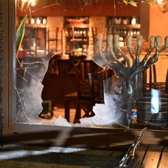 Das beschädigte Fenster des israelischen Lokals in München