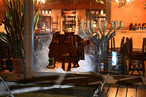 Das beschädigte Fenster des israelischen Lokals in München
