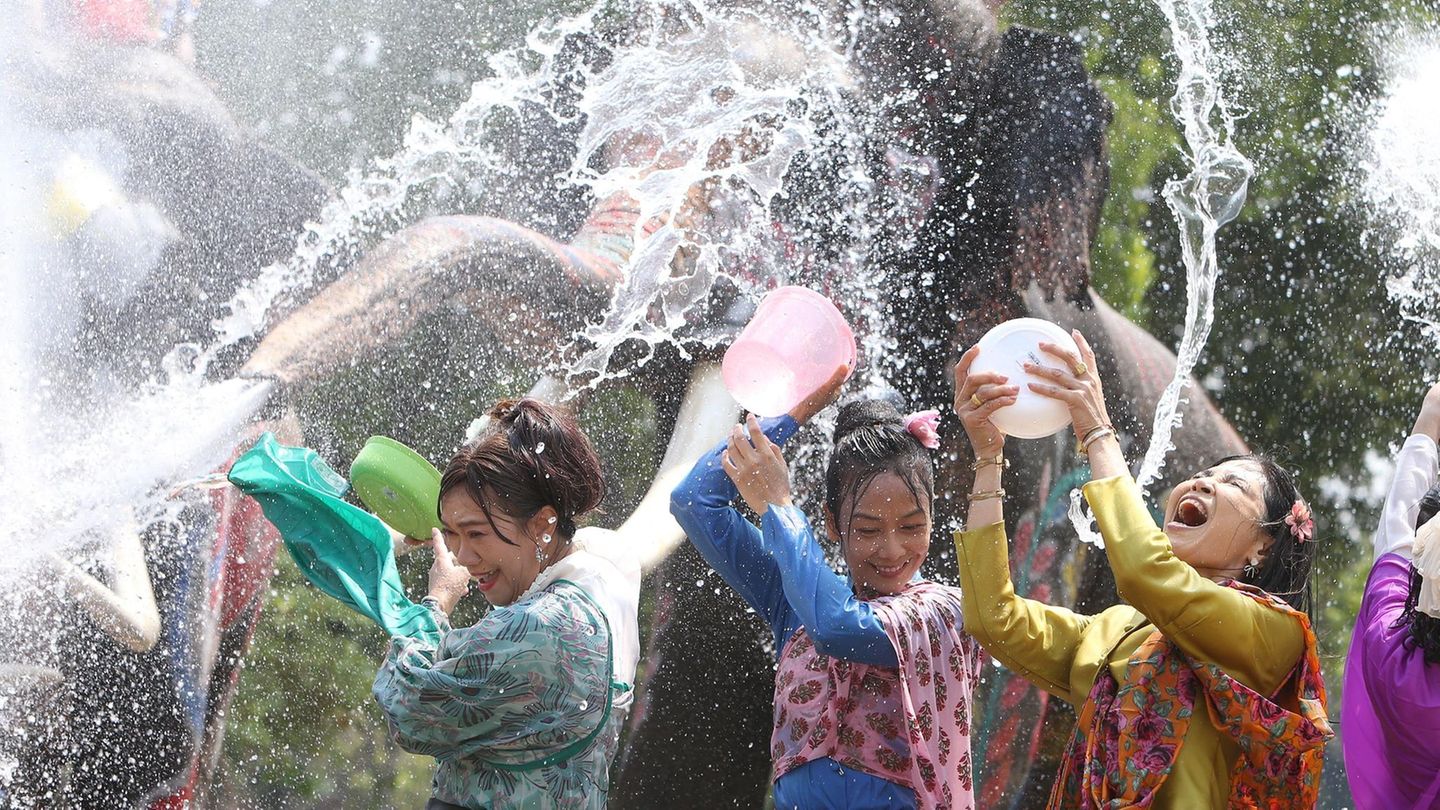 Ayutthay, Thailand. Menschen und Elefanten spritzen mit Wasser, um das bevorstehende Songkran-Fest zu feiern. Songkran, das in Thailand normalerweise vom 13. bis 15. April gefeiert wird, wird auch in Laos, Kambodscha und Myanmar begangen. Der Feiertag, der als buddhistisches Neujahrsfest bekannt ist, wurde traditionell mit Besuchen bei Familienmitgliedern und dem Übergießen von Buddha-Statuen mit duftendem Wasser begangen. Das Spritzen von Wasser symbolisiert das Abwaschen des Unglücks des vergangenen Jahres.