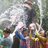 Ayutthay, Thailand. Menschen und Elefanten spritzen mit Wasser, um das bevorstehende Songkran-Fest zu feiern. Songkran, das in Thailand normalerweise vom 13. bis 15. April gefeiert wird, wird auch in Laos, Kambodscha und Myanmar begangen. Der Feiertag, der als buddhistisches Neujahrsfest bekannt ist, wurde traditionell mit Besuchen bei Familienmitgliedern und dem Übergießen von Buddha-Statuen mit duftendem Wasser begangen. Das Spritzen von Wasser symbolisiert das Abwaschen des Unglücks des vergangenen Jahres.