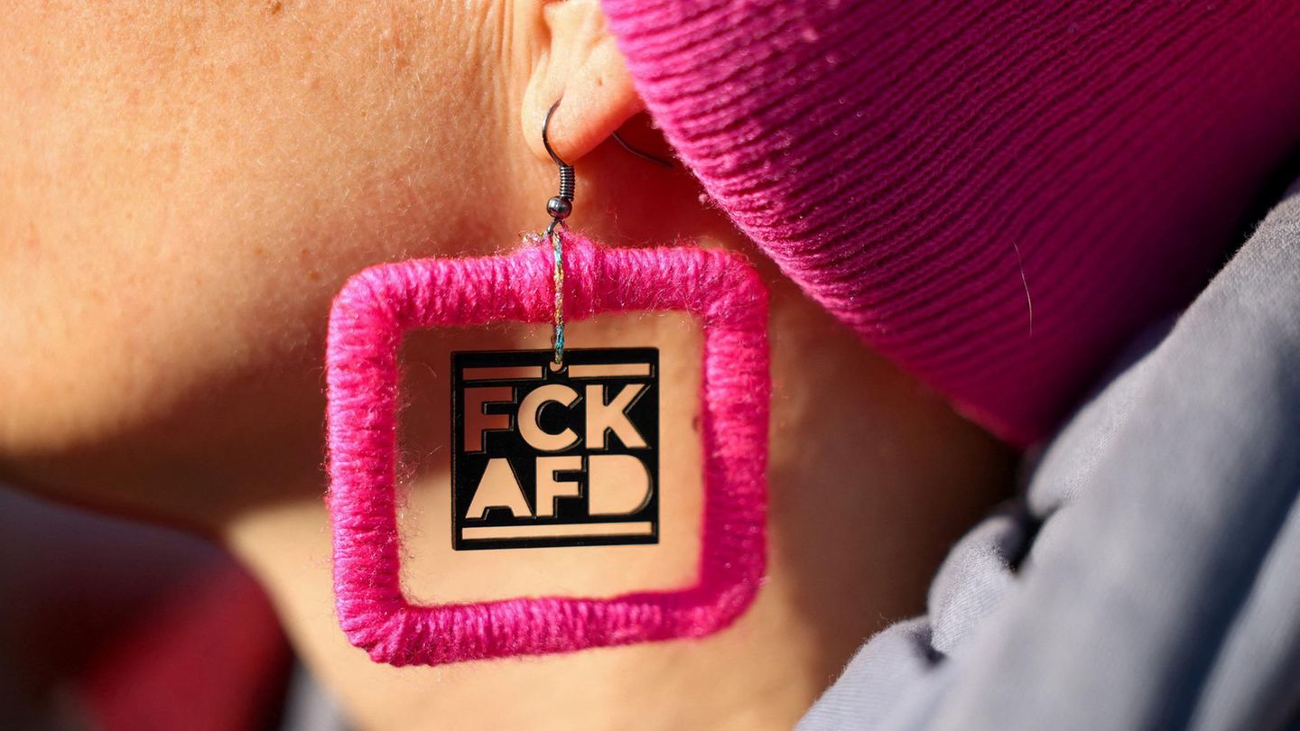 Eine Frau trägt einen pinkfarbigen Ohrring mit einem Anti-AFD Schriftzug