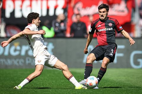 Tom Baack (r, 1. FC Nürnberg) und Ben Bobzien (Dynamo Dresden) kämpfen um den Ball. Foto: Daniel Karmann/dpa